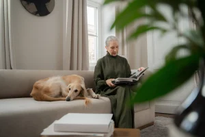 Older woman relaxing at home beside her dog.